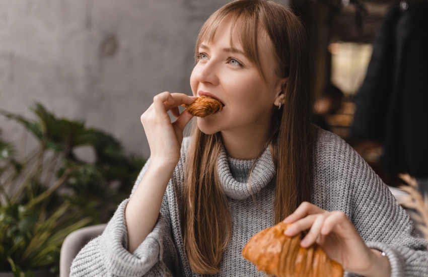 красивая девушка, круассан, серый свитер